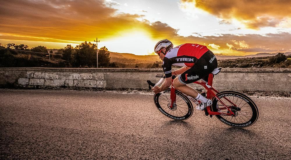 Road cyclist on descent at sunset